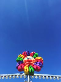 Low angle view of multi colored balloons against blue sky