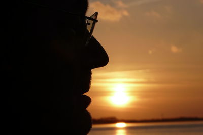 Silhouette of man against sea during sunset