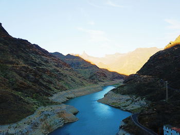 Scenic view of river amidst mountains against sky