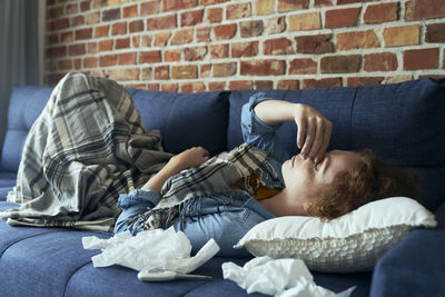 Low section of woman lying on bed at home