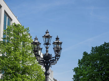 Low angle view of street light by building against sky