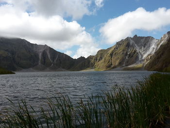 Scenic view of mount pinatubo by lake against cloudy sky