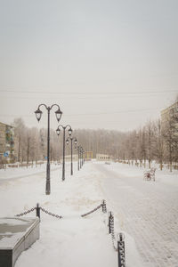 Snow covered street against sky