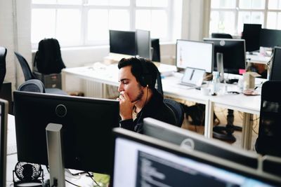 Young man by computer in office