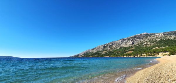 Scenic view of sea against clear blue sky