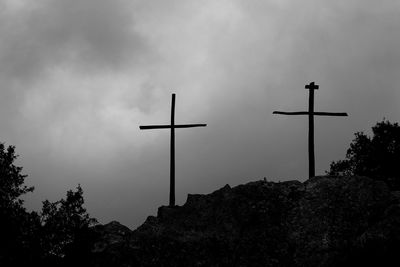 Low angle view of silhouette cross against sky