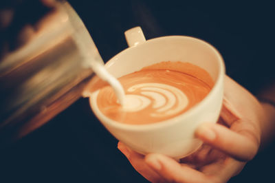 Close-up of hand holding coffee cup