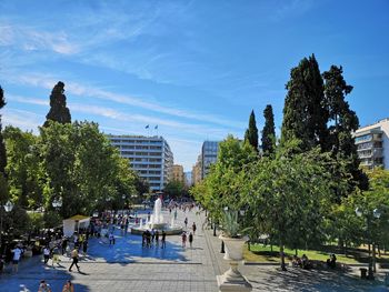Group of people in park against buildings in city
