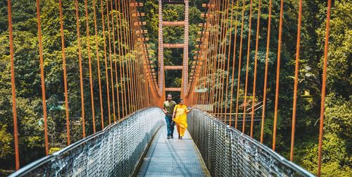 Man on footbridge in forest