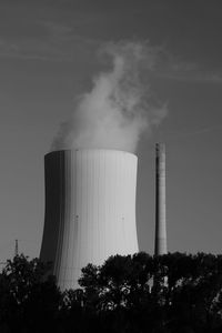 Low angle view of smoke emitting from factory against sky