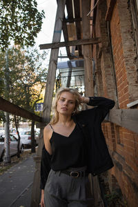 Portrait of woman standing against built structure