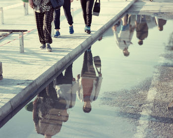 Low section of people with reflection on water