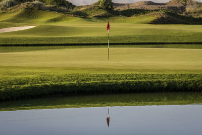 Scenic view of golf course by lake