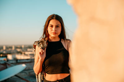 Portrait of young woman on terrace during sunset