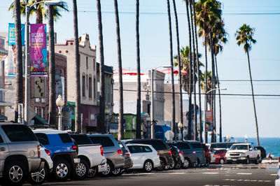 Cars on street in city against clear sky