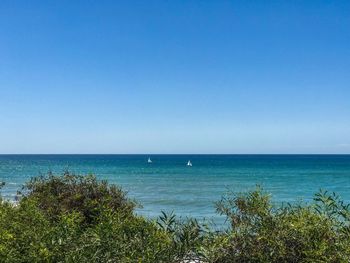 Scenic view of sea against clear blue sky