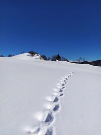 Scenic view of snowcapped mountains against clear blue sky