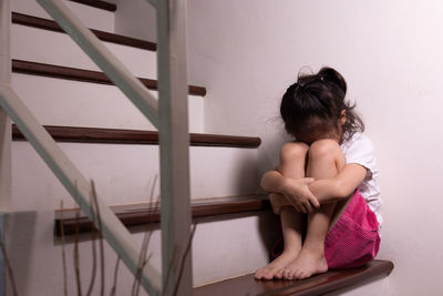 Rear view of boy sitting on staircase