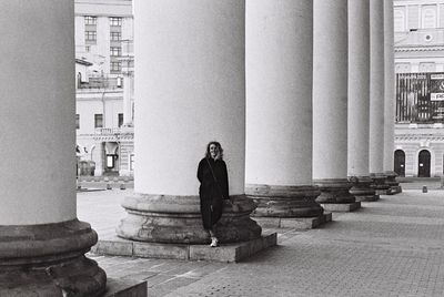 Full length of woman standing against column