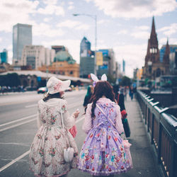 Women in costumes in city against sky