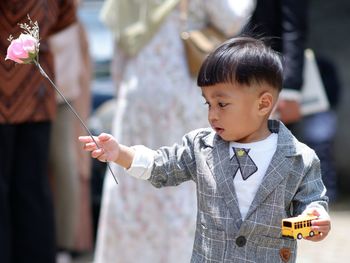 Portrait of cute toddler boy holding flower