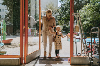 Granddaughter with grandmother arriving at kindergarten