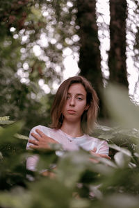 Portrait of young woman against trees