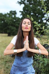 Woman with eyes closed standing on field