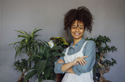 Portrait of young woman looking away against wall