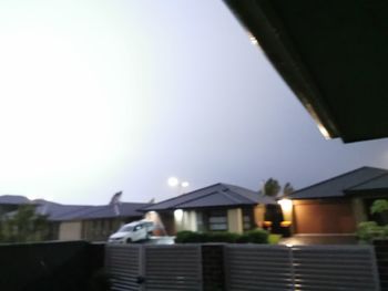 Illuminated houses against sky at dusk