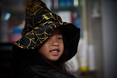 Portrait of girl wearing witch hat at home