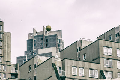 Low angle view of modern buildings against cloudy sky