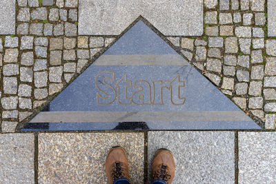 Low section of person standing on footpath