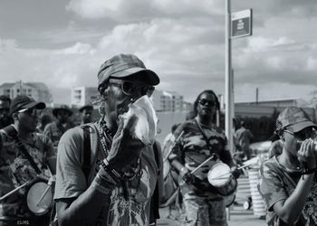 People looking at city street against sky