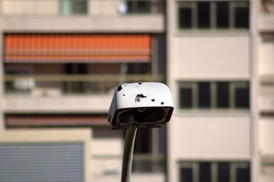 Close-up of broken street light against building