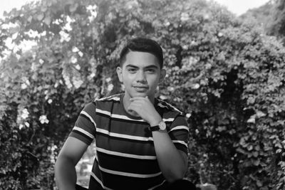 Portrait of young man against trees