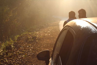 Friends standing by car on roadside