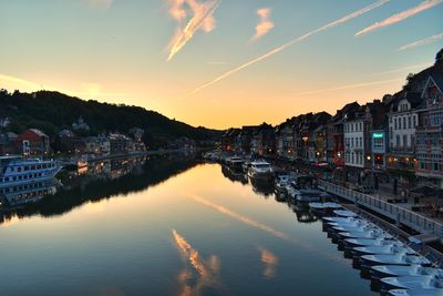 View of canal and houses against sky at sunset