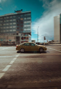 Car on street against buildings in city