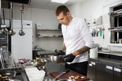 Young man preparing food in kitchen