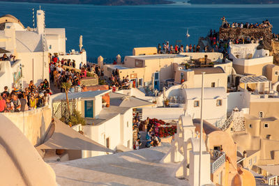 Tourists looking at the amazingly beautiful sunset at la caldera in oia city in santorini island