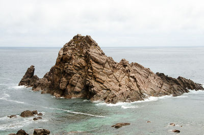 Scenic view of rock formation in sea against sky