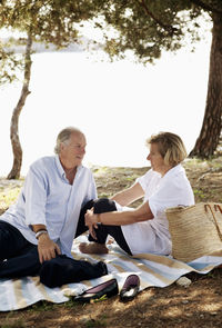 Senior man and mature woman enjoying picnic together