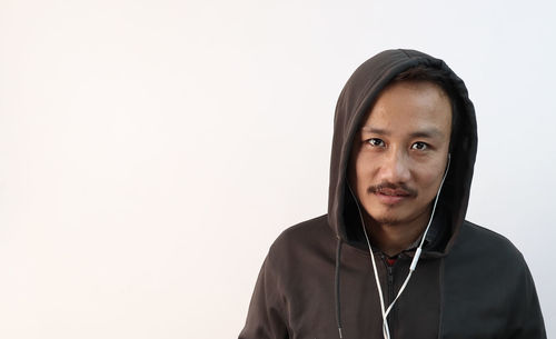 Portrait of mid adult man standing against white background