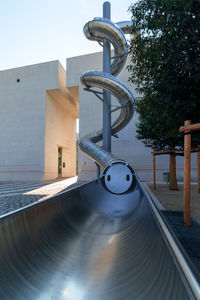 Metal structure by building against clear sky