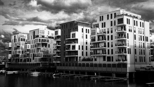 Buildings in city against cloudy sky