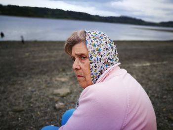 Side view of senior woman sitting at beach