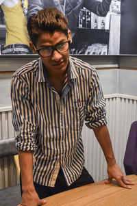 Midsection of man standing by table