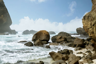 Rocks in sea against sky