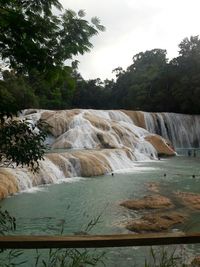 Scenic view of waterfall against sky